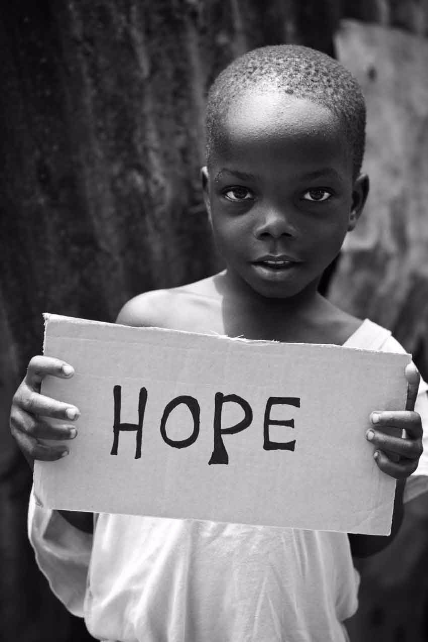 Hands holding a sign that reads HOPE